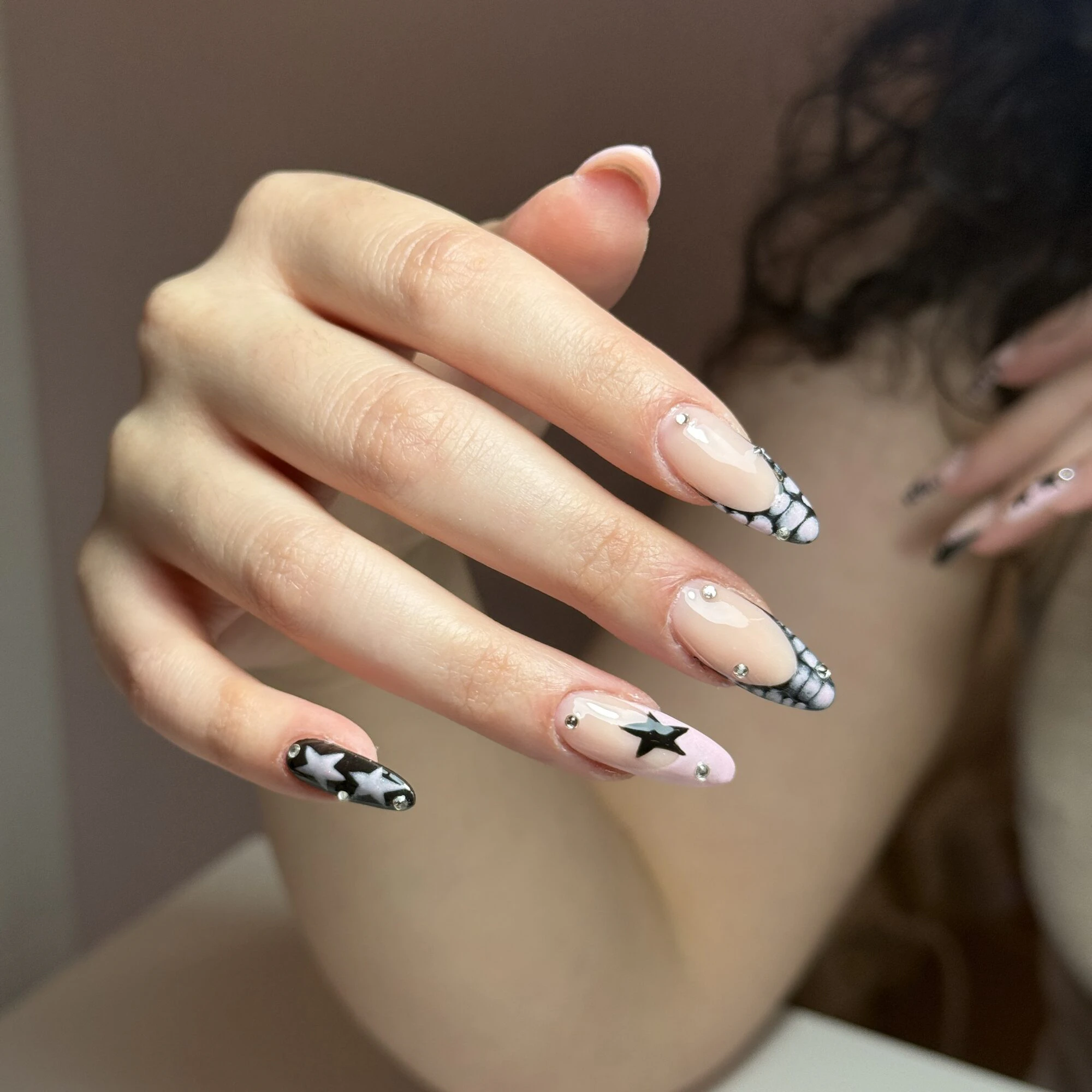 Nail art con stelle e quadretti bianchi e neri